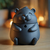 3D printed hamster memorial urn with removable lid displayed on a wooden table in warm cozy lighting.
