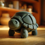 3D printed turtle memorial urn with removable lid and shell details displayed on a wooden table in warm indoor lighting.