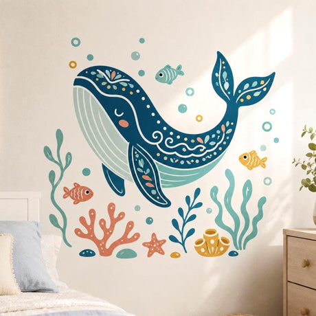 Stylized dark teal whale with a peaceful closed eye and decorative floral patterns, surrounded by three small fish, bubbles, coral, seaweed, a starfish, stones, and yellow sea sponges in teal, mint, coral, and mustard tones.