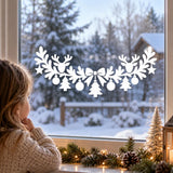 White vinyl festive window design with two reindeer, small trees, baubles and star accents
