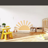 Minimalist sun wall decal in a bright nursery with yellow accents.