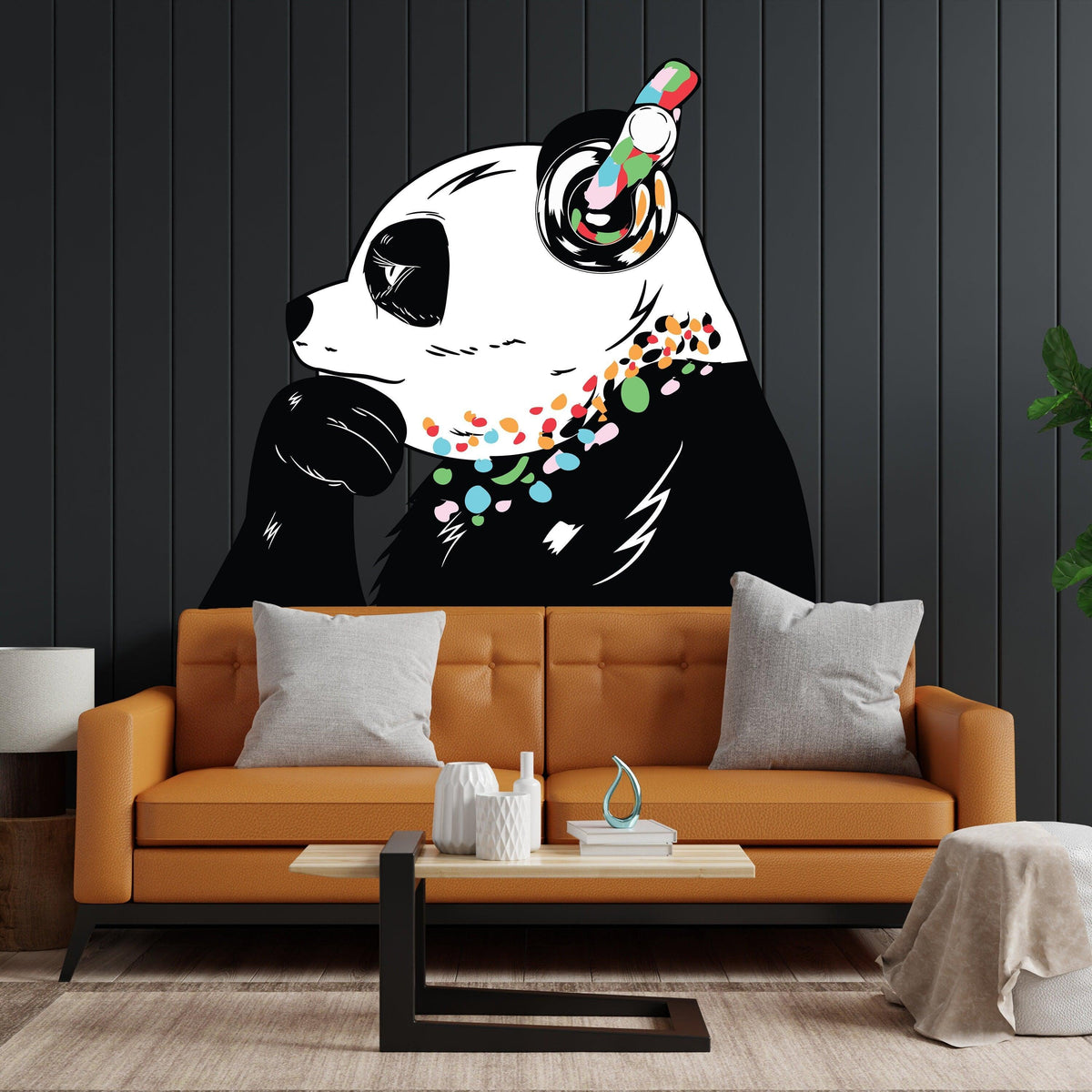 Expressive panda wall decal on a dark wall above a stylish orange sofa, enhancing room decor with vibrant colors.
