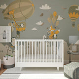 Stylish nursery featuring whimsical wall decals of penguins and foxes with hot air balloons.