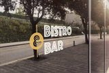 Наклейка с надписью Bistro and Bar на стеклянной витрине.