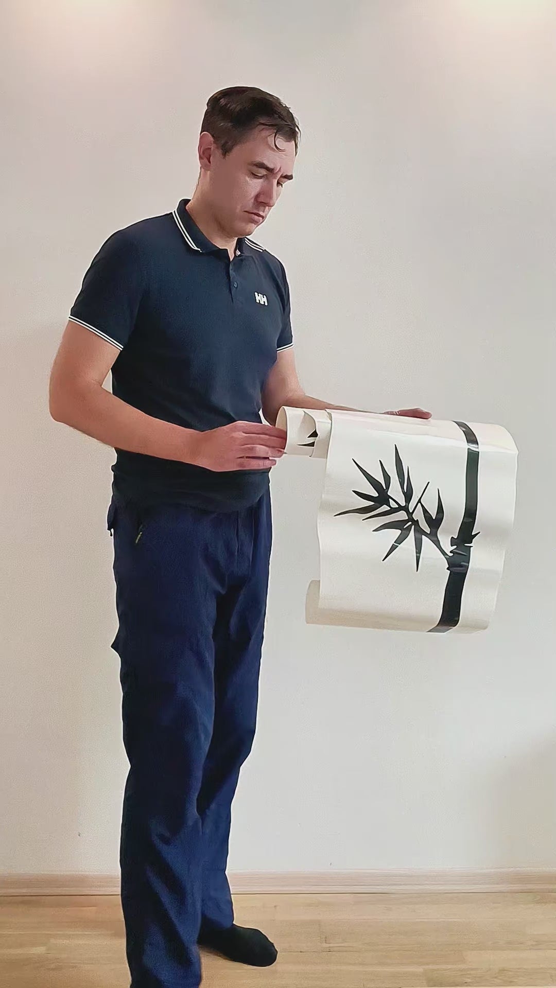 Person applying a bamboo wall decal in a product video.