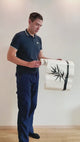 Person applying a bamboo wall decal in a product video.