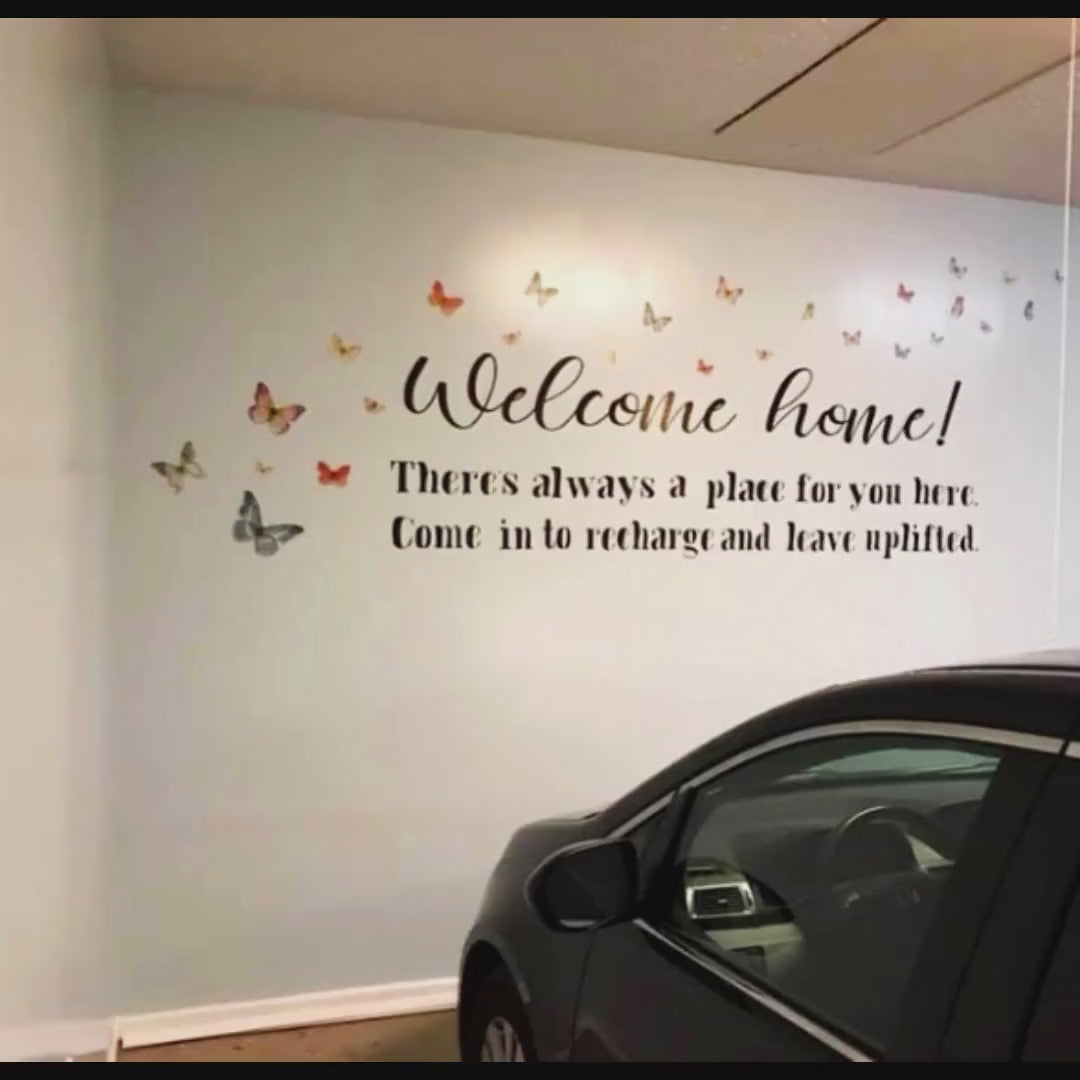 Vinyl wall decal featuring the message 'Welcome home!' with colorful butterfly accents.