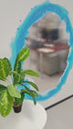 Blue and orange portal aura wall sticker with a reflective surface, surrounded by a green potted plant.