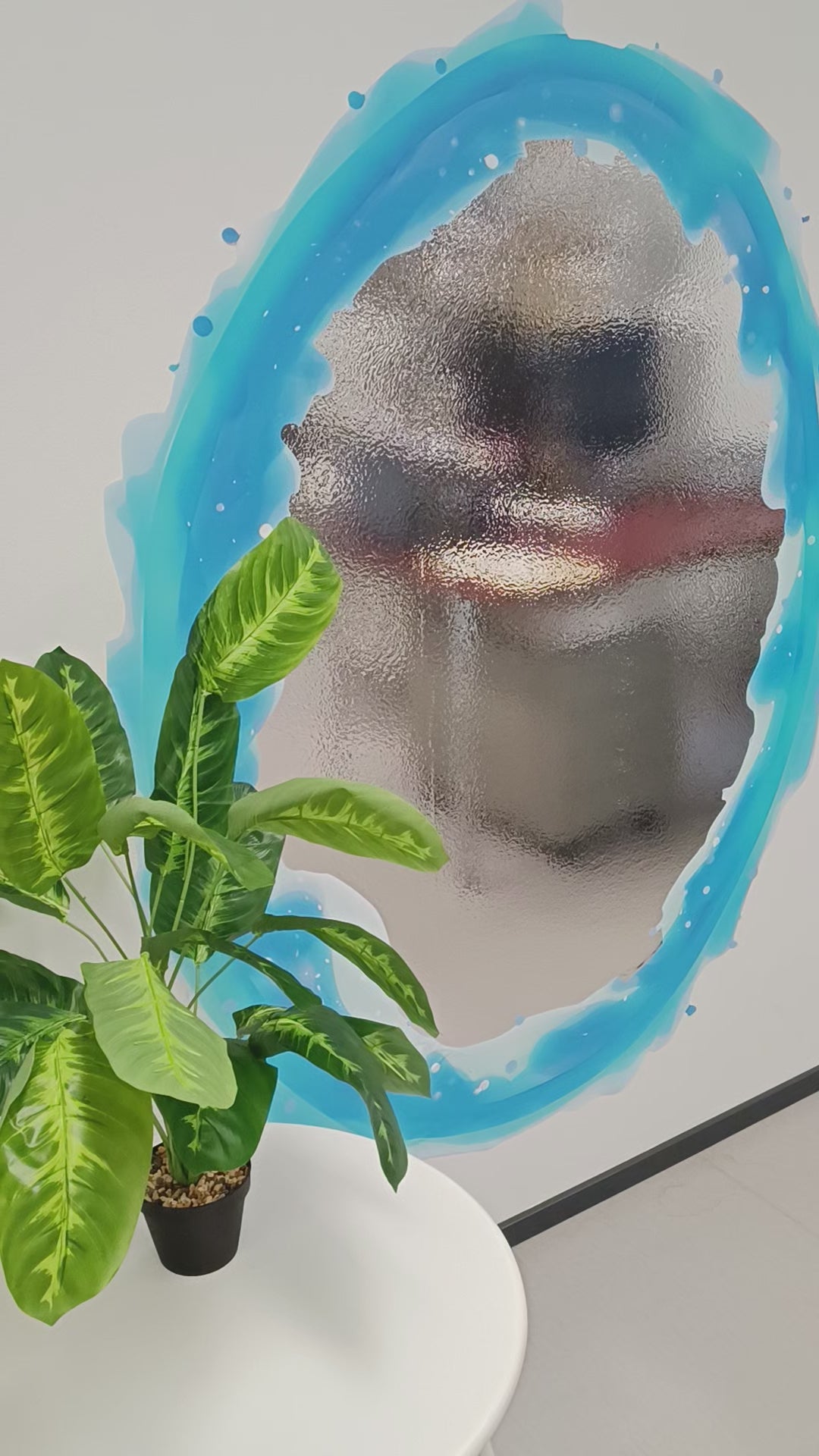 Blue and orange portal aura wall sticker with a reflective surface, surrounded by a green potted plant.