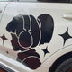 Stylish silhouette of a girl with headphones on a car door, accented with star designs.