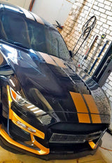 Оранжевые гоночные полосы на чёрном автомобиле в гараже.