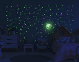 Glowing star stickers and moon decal on a dark wall, creating a magical night sky in a child's bedroom.