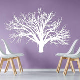 Nature's Serenity vinyl wall decal featuring a white tree design on lavender wall with modern chairs.