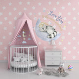 Adorable nursery design with a soft pink wall and star motifs.