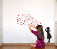 Girl applying heart bubble wall decal in a stylish room, showcasing playful street art design.