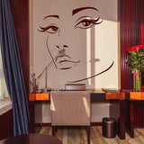 Charming woman face vinyl wall decal in elegant interior with desk and flowers.