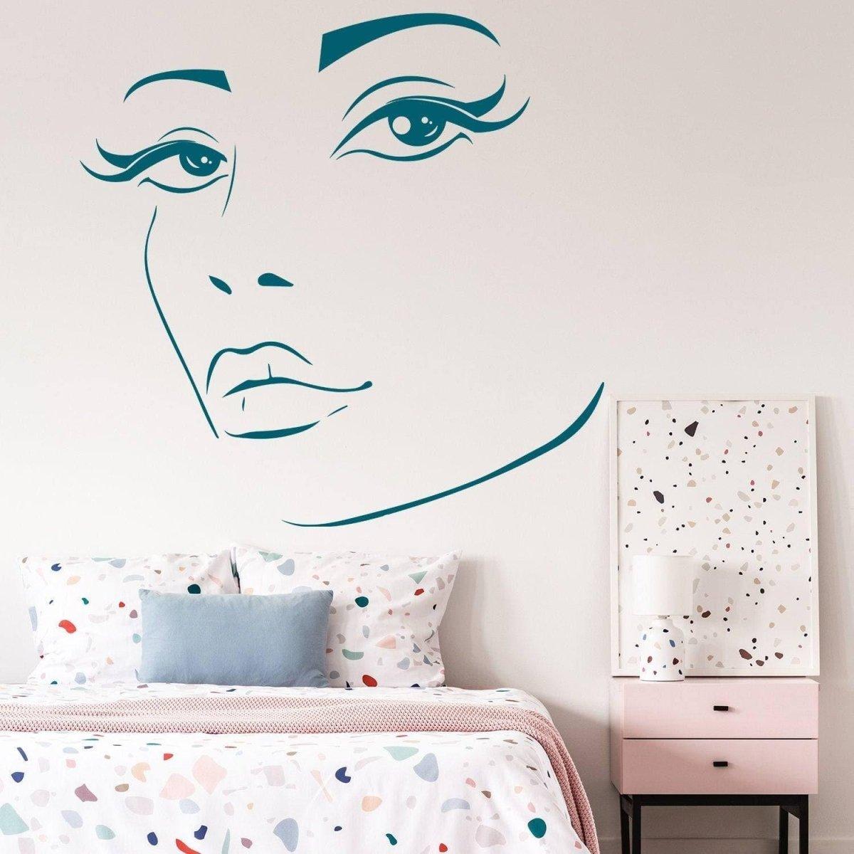 Charming woman face vinyl wall decal above a colorful bed.