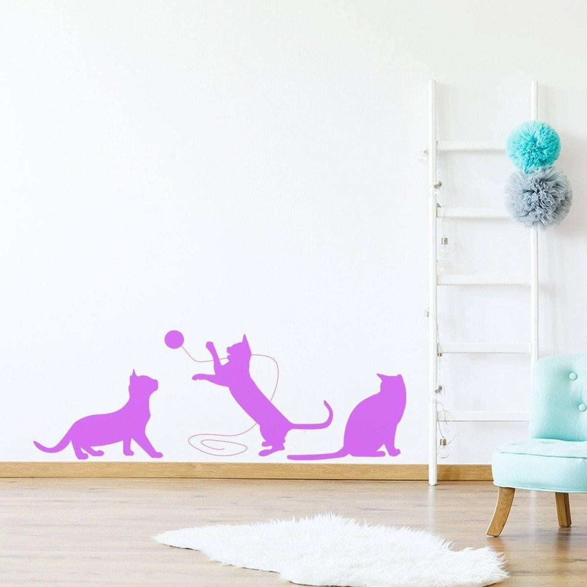 Adorable pink vinyl cat silhouette decal depicting playful cats on a wall.