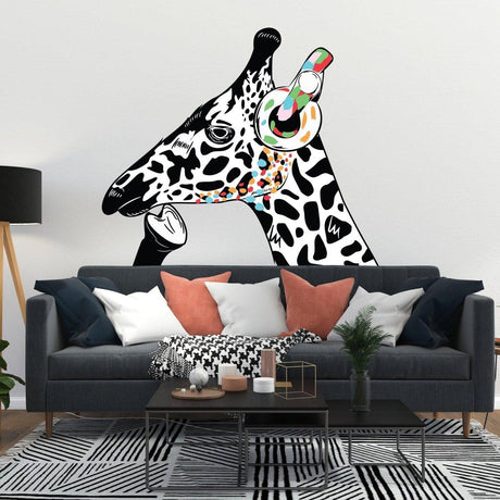 Contemplative giraffe wall sticker with colorful headphones on white wall above modern sofa.