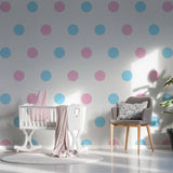 Colorful blue and pink circle wall decals in a cozy nursery with a crib and chair.