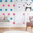 Colorful nursery with pink and blue circle wall stickers, animal art, and a cozy crib for playful decor.
