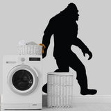 BigFoot vinyl decal silhouette on a wall beside a washing machine and laundry baskets, adding charm to any space.