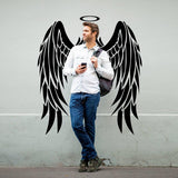 Man standing with angel wings wall sticker, offering a whimsical touch to any space.