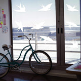 Frosted bird silhouette decals on glass window, enhancing aesthetics while preventing bird collisions.
