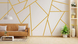 Elegant geometric gold wall stickers in a modern living room with a brown sofa and decorative plants.