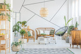 Stylish living room with geometric wall art, rattan furniture, and indoor plants for a modern decor.