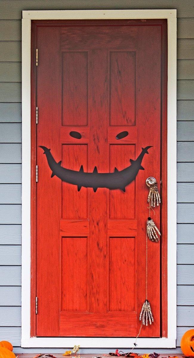 Graphic grinning face vinyl decal displayed on a red door.