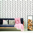 Herringbone wall stickers in black on white background with a cozy couch and decorative blanket in a stylish living room.