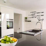 Kitchen with humorous family rules wall decal, featuring chef illustration, modern decor, and a bowl of fresh fruits.