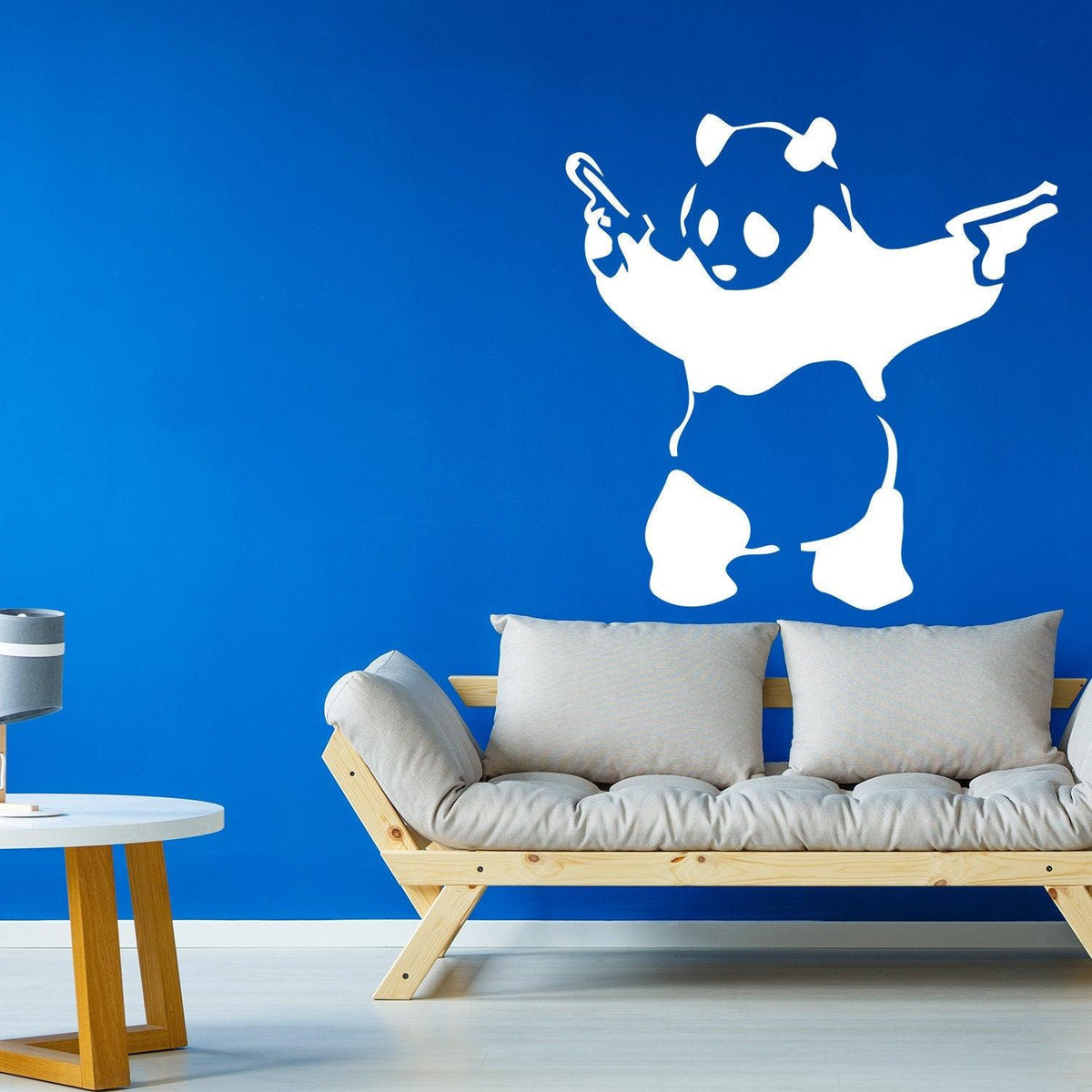 Panda with pistols wall sticker displayed on a blue wall.