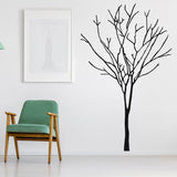 Black tree wall decal in a modern room with green chair and art.