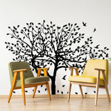 Black tree wall decal with birds and leaves in a cozy living space with modern chairs.