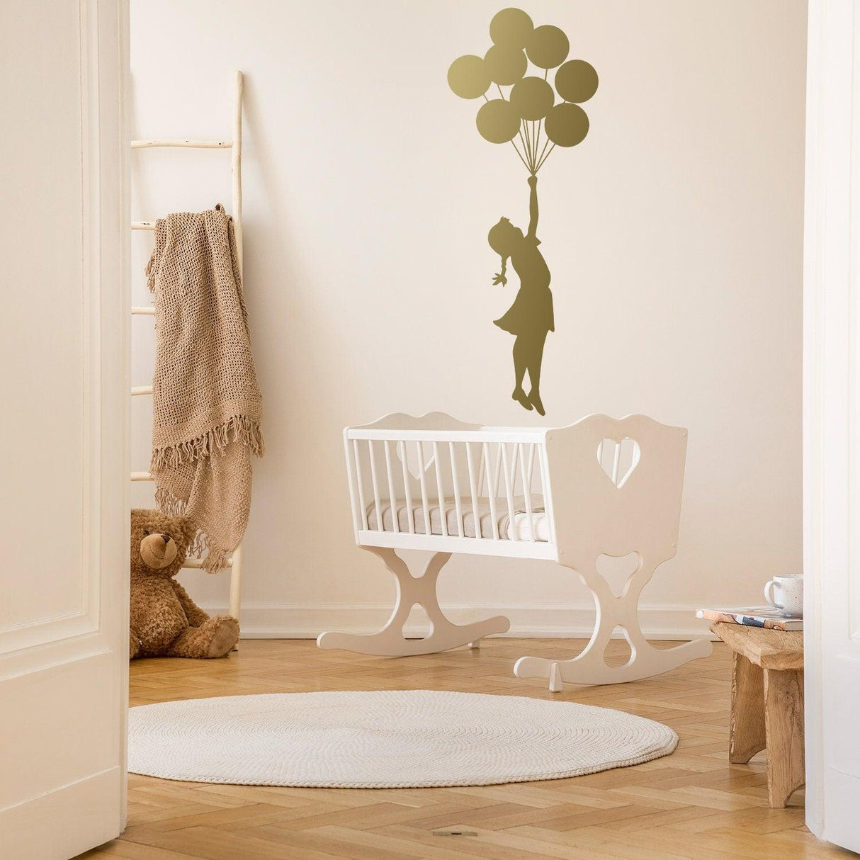 Balloon girl wall sticker displayed in a nursery with a crib.