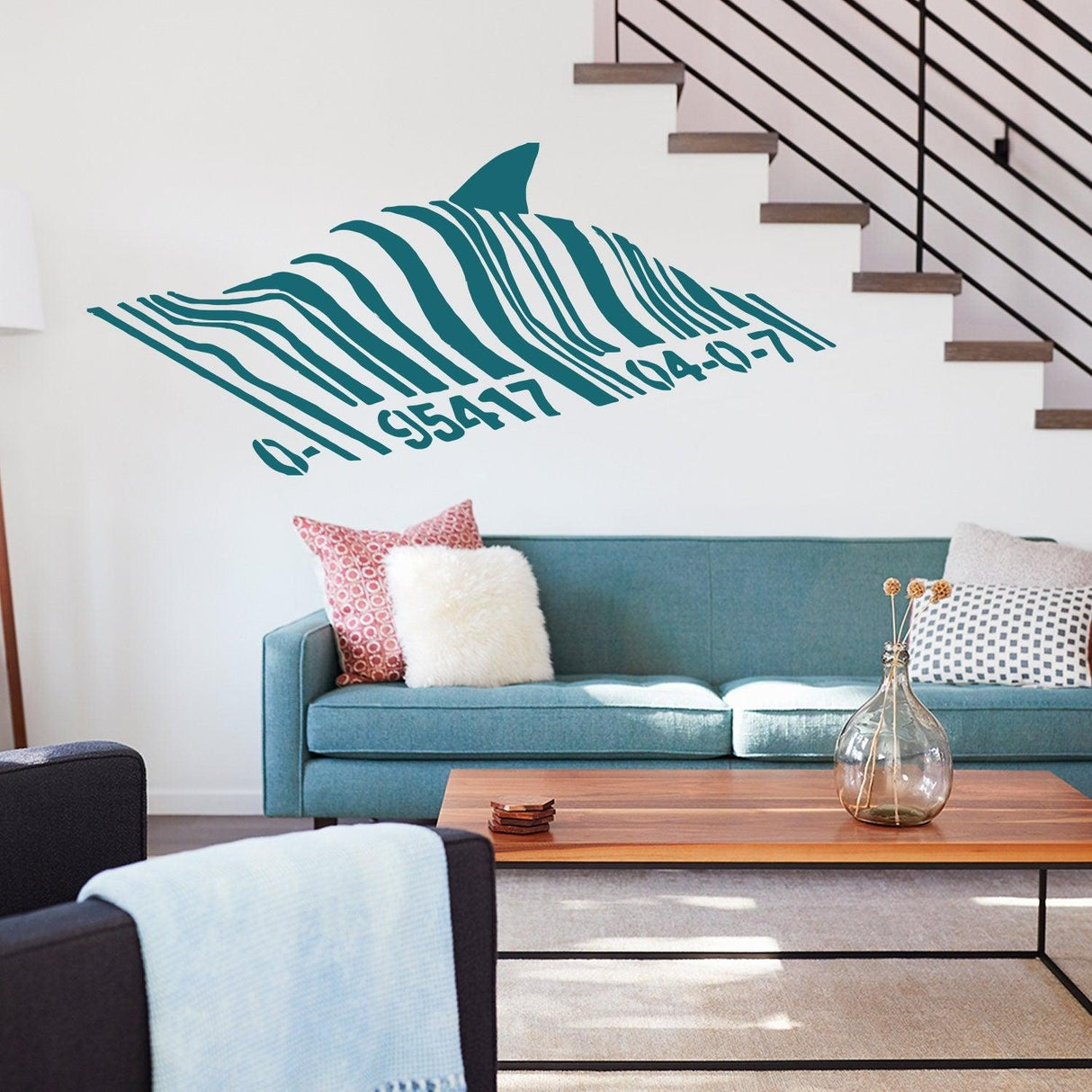 Barcode shark wall sticker above a teal sofa in a modern living room.