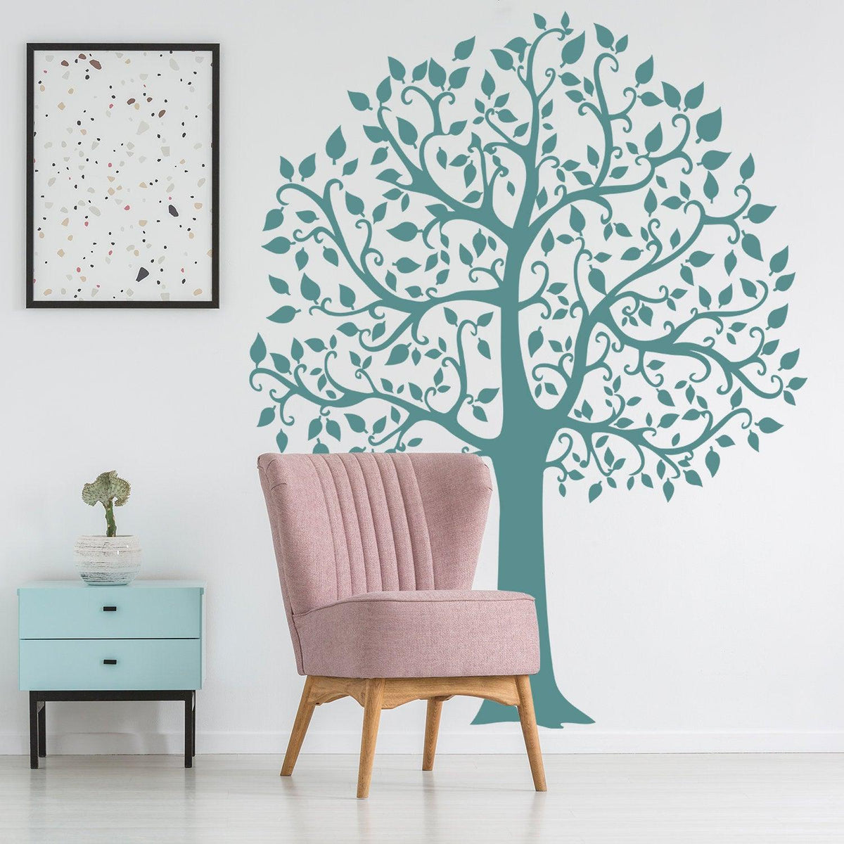 Birch tree wall decal in a nursery with pink chair and blue side table, adding nature-inspired decor.