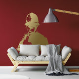 Gold policeman middle-finger wall decal displayed above a sofa on a red wall.