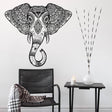 Elephant head wall vinyl sticker featuring Aztec geometric design above a chair and side table with decor.