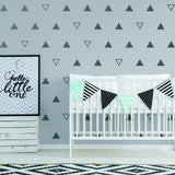 Nursery decor featuring 40x triangle wall vinyl decals in black on a gray wall, with a crib and decorative banners.