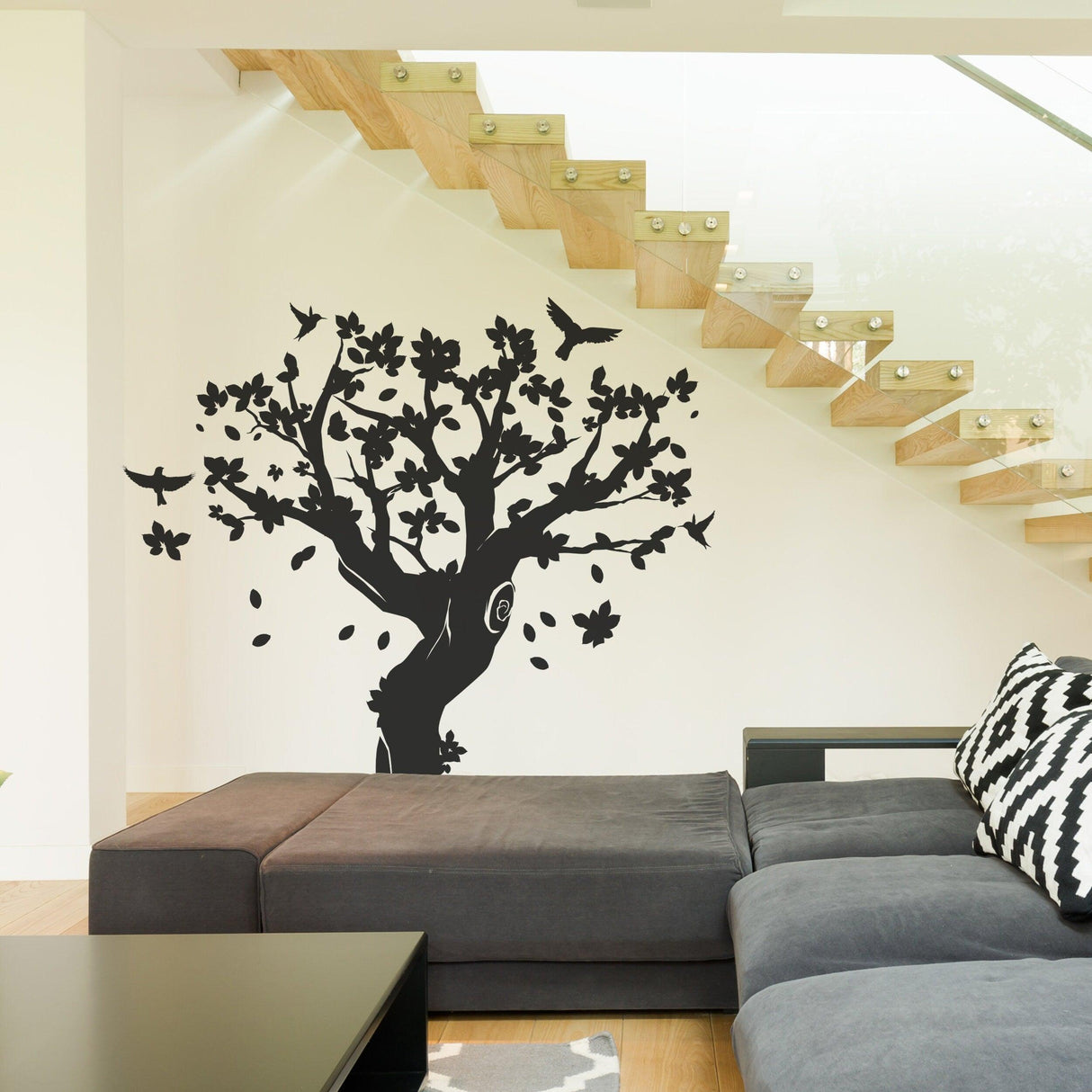Black tree wall decal with birds and flowers in a modern living space.