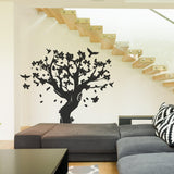 Black tree wall decal with birds and flowers in a modern living space.