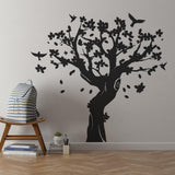 Large black tree wall decal with birds and flowers in kids room.
