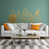 Patterned mountain wall decor vinyl decal in a kid's room above a modern sofa with orange pillows.