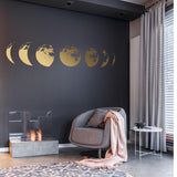 Elegant gold moon phases wall decal above modern chair and cozy throw in stylish living room decor.