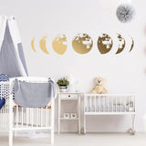 Gold moon phases wall decal in a nursery, adding elegance to baby room decor with a cute teddy bear.