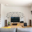 Vinyl circuit board wall decal above modern TV in stylish living room, enhancing decor with unique design.