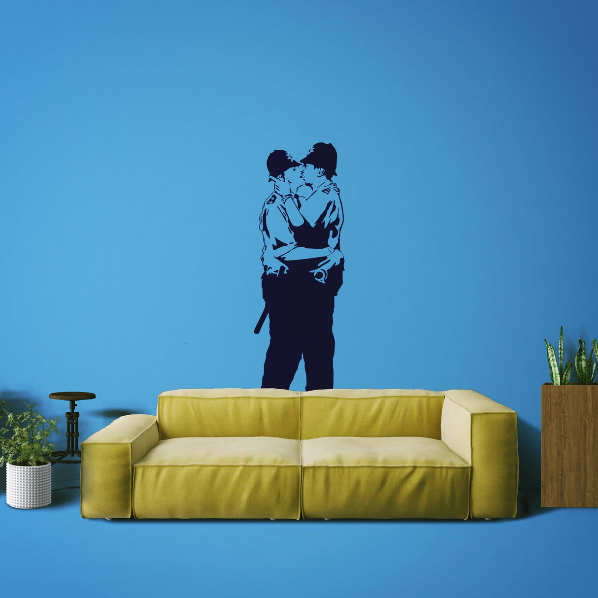 Police kissing wall sticker on a blue wall above a yellow couch.